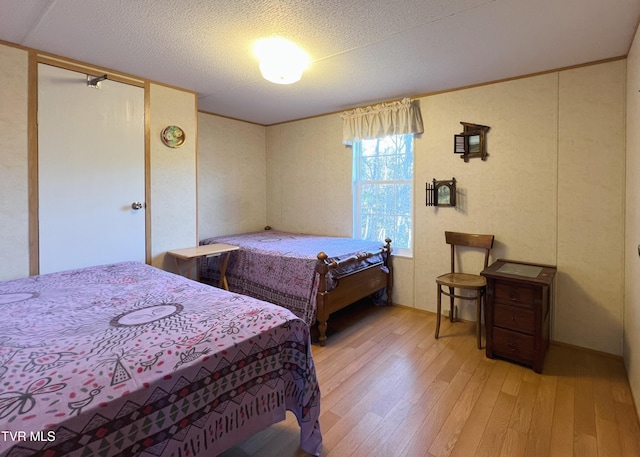 bedroom with hardwood / wood-style floors and a textured ceiling