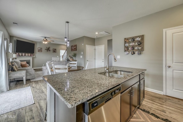 6758 Wildlife Cir, Piney Flats, TN 37686 - kitchen with sink, light hardwood / wood-style flooring, dishwasher, light stone countertops, and an island with sink