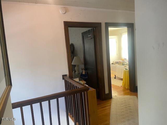 hallway with an upstairs landing and light wood-type flooring