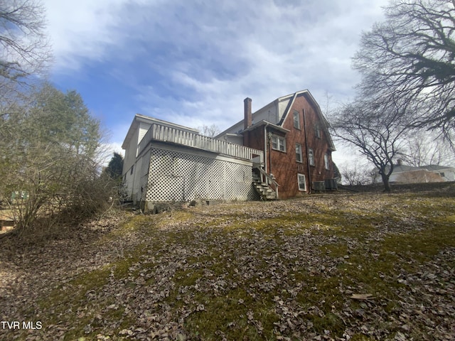 view of side of property with a gambrel roof and central AC