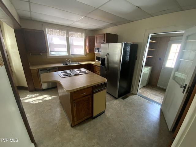 kitchen with a healthy amount of sunlight, stainless steel appliances, and a paneled ceiling