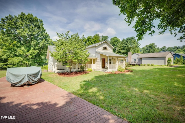 view of front of house with an outdoor structure, a front lawn, and a porch