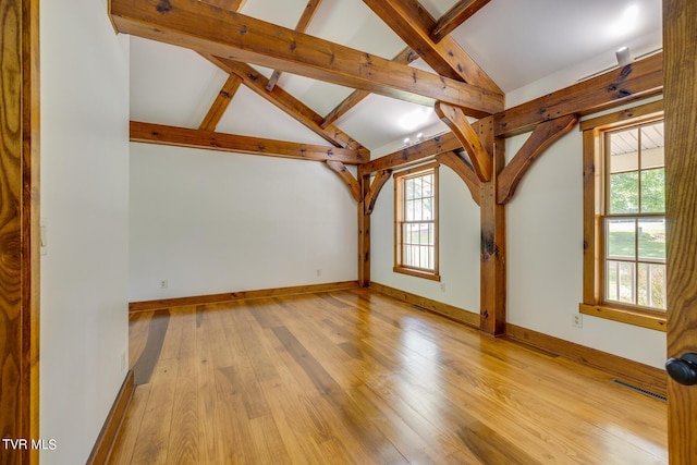 interior space with plenty of natural light, vaulted ceiling with beams, and light hardwood / wood-style floors