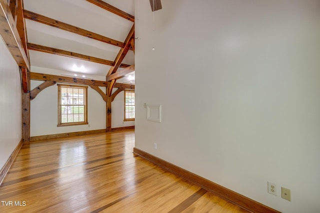 additional living space with lofted ceiling with beams and light hardwood / wood-style flooring