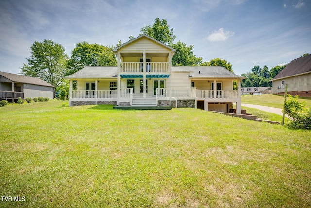 back of house with a balcony, covered porch, and a lawn