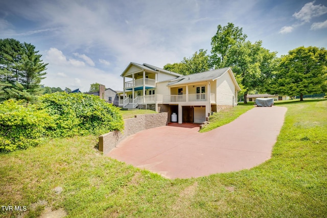 rear view of property with a balcony and a lawn