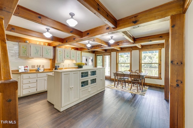 kitchen with beam ceiling, dark wood-type flooring, a center island, and white cabinets