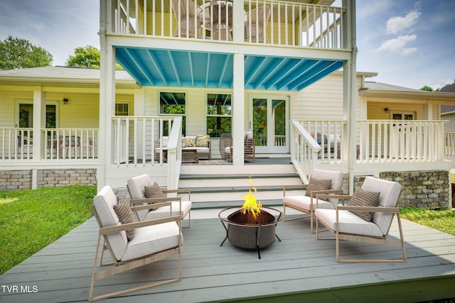 deck featuring an outdoor living space with a fire pit