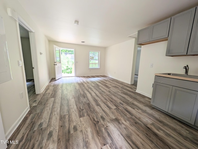 unfurnished living room featuring dark hardwood / wood-style floors and sink