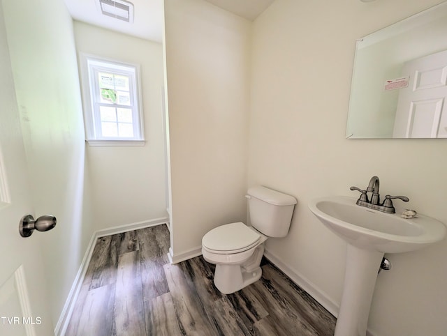 bathroom featuring hardwood / wood-style flooring and toilet