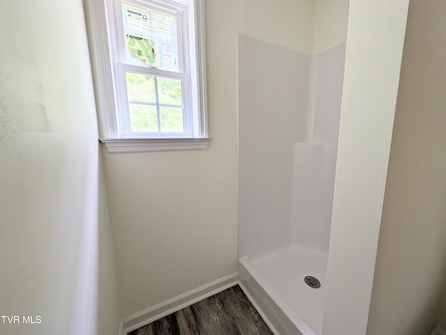 bathroom with a shower and wood-type flooring