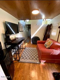 living room featuring hardwood / wood-style flooring and wooden ceiling