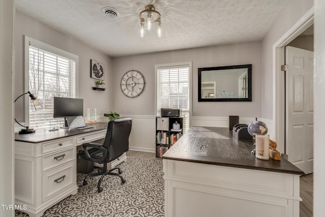 office space featuring light wood-type flooring and a textured ceiling