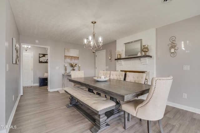 dining room featuring hardwood / wood-style flooring, a textured ceiling, and an inviting chandelier