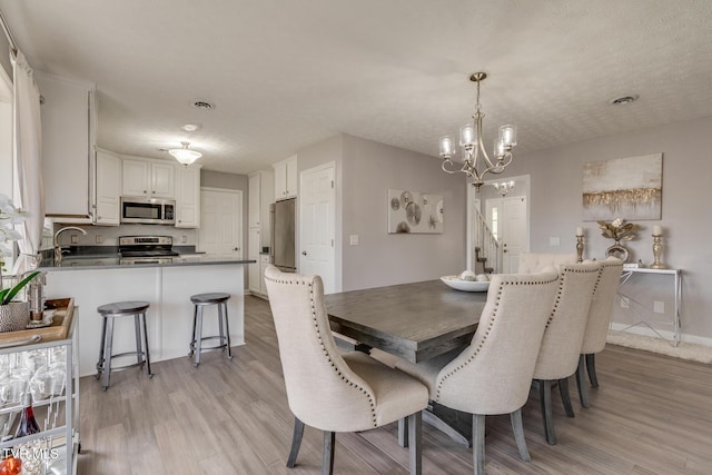 dining space with a notable chandelier and light wood-type flooring