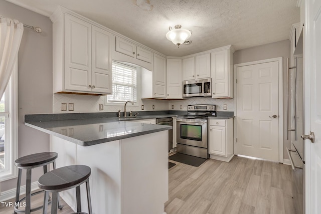 kitchen featuring sink, white cabinets, and appliances with stainless steel finishes