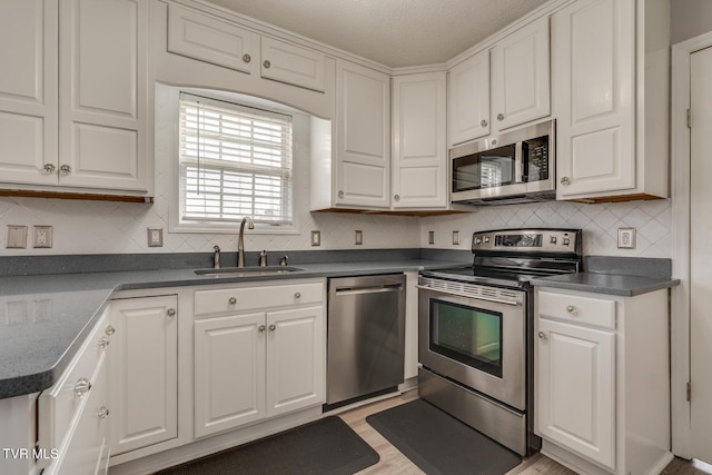 kitchen featuring white cabinetry, sink, decorative backsplash, and appliances with stainless steel finishes