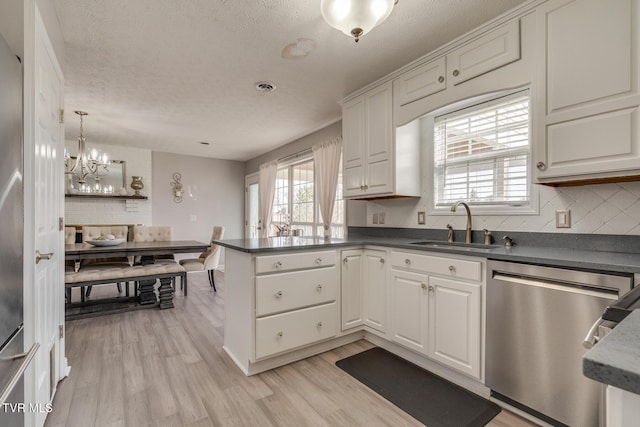 kitchen featuring white cabinetry, sink, kitchen peninsula, and dishwasher