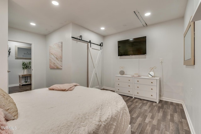 bedroom with hardwood / wood-style flooring and a barn door