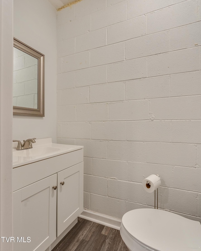 bathroom featuring wood-type flooring, vanity, and toilet