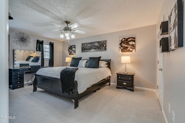 bedroom with ceiling fan, light carpet, and a textured ceiling