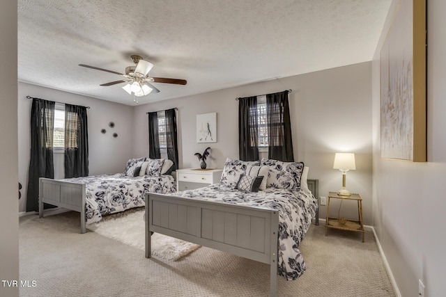 bedroom featuring ceiling fan, light colored carpet, and a textured ceiling