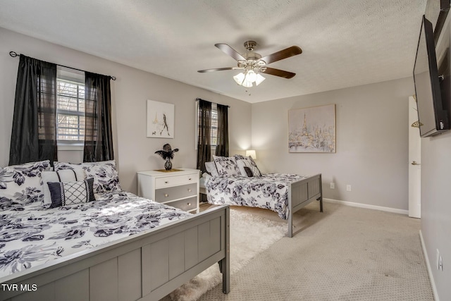 carpeted bedroom with ceiling fan and a textured ceiling