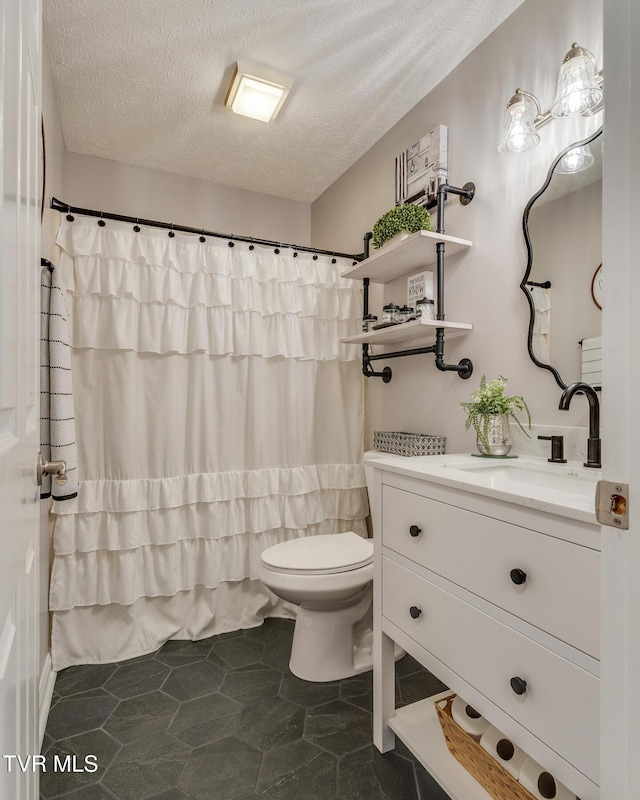 bathroom with vanity, a textured ceiling, and toilet