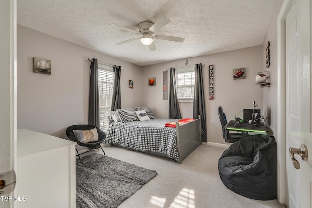 bedroom with multiple windows, ceiling fan, carpet flooring, and a textured ceiling