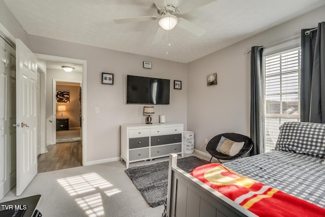 carpeted bedroom featuring a textured ceiling and ceiling fan