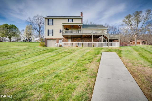 rear view of property featuring a garage, a wooden deck, and a yard