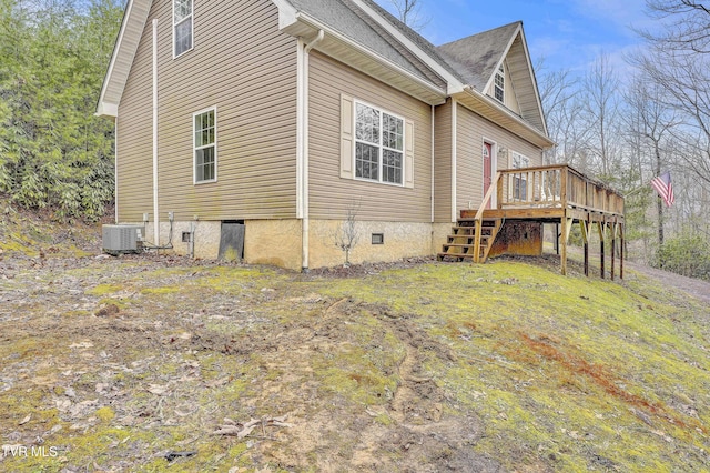 view of side of home with a deck and central AC unit