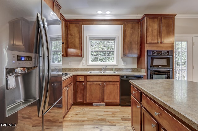 kitchen featuring sink, crown molding, black appliances, and light hardwood / wood-style floors