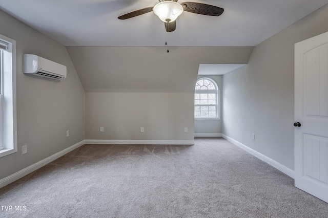 bonus room featuring vaulted ceiling, light colored carpet, an AC wall unit, and ceiling fan