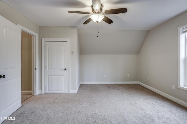 additional living space with light carpet, lofted ceiling, and ceiling fan