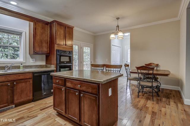 kitchen with light hardwood / wood-style floors, a center island, sink, and black appliances