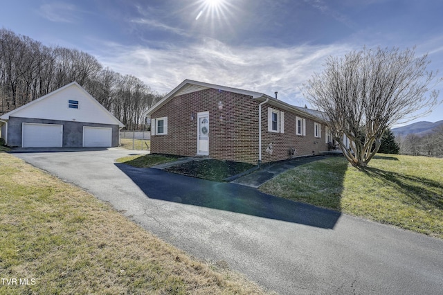 view of side of home with a garage, a yard, and an outdoor structure