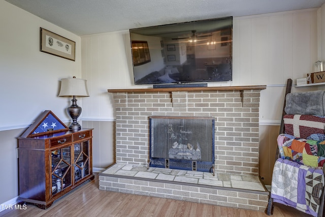 room details featuring hardwood / wood-style floors, a fireplace, and a textured ceiling