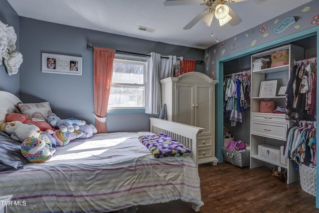 bedroom featuring ceiling fan, dark wood-type flooring, a closet, and a textured ceiling