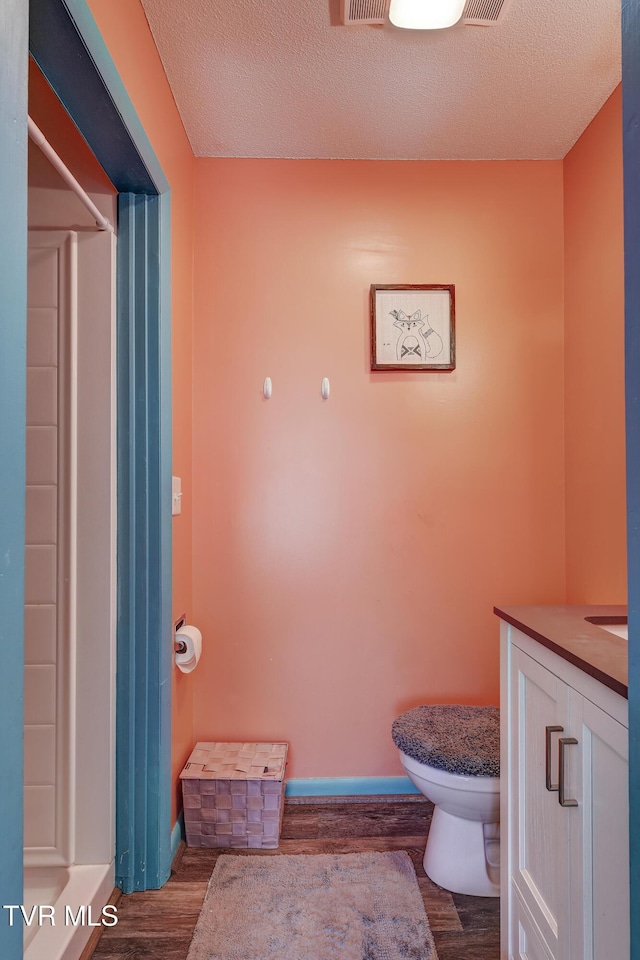 bathroom featuring hardwood / wood-style flooring, vanity, and a textured ceiling