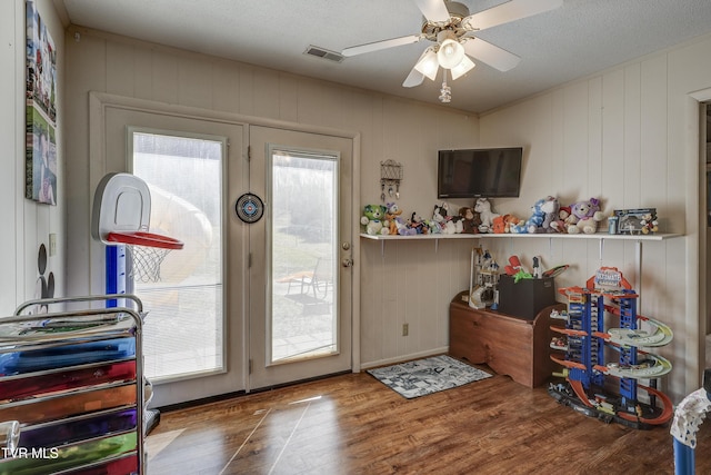 doorway to outside with hardwood / wood-style floors, a textured ceiling, and ceiling fan