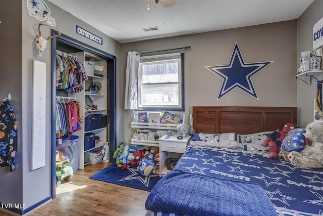 bedroom with hardwood / wood-style flooring, a closet, and a textured ceiling