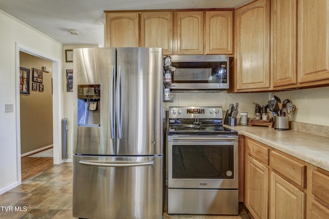 kitchen featuring stainless steel appliances, a textured ceiling, and light brown cabinets