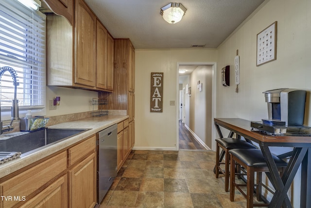 kitchen with sink, stainless steel dishwasher, and a textured ceiling