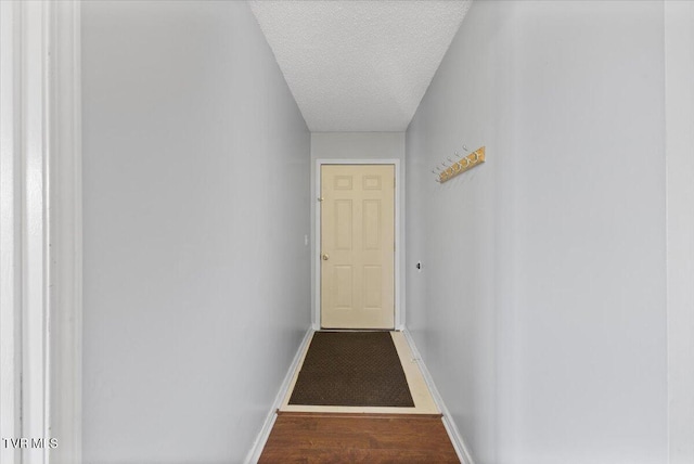 hallway with hardwood / wood-style flooring and a textured ceiling