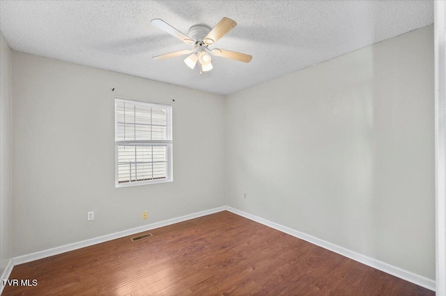 unfurnished room with ceiling fan, dark wood-type flooring, and a textured ceiling