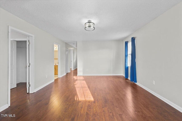 unfurnished room featuring dark hardwood / wood-style floors and a textured ceiling