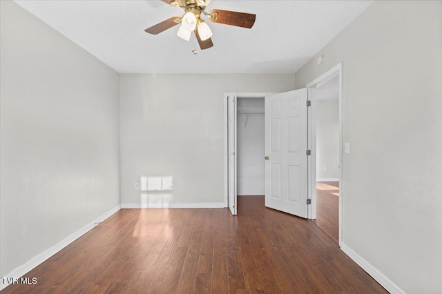 unfurnished bedroom with dark hardwood / wood-style floors, ceiling fan, and a closet