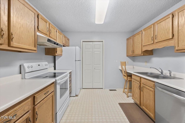 kitchen with sink, light brown cabinetry, a textured ceiling, and white appliances