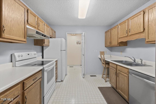 kitchen featuring sink, a textured ceiling, and white appliances